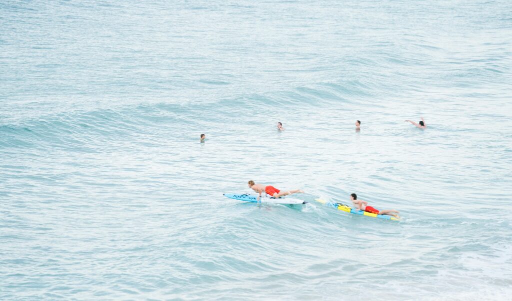 surferos remando energicamente