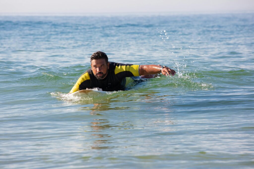 surfer remando fuerza ola