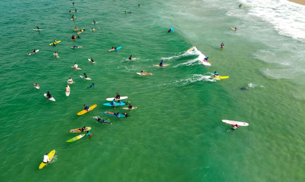 surfistas esperando a entrar en la ola perfecta