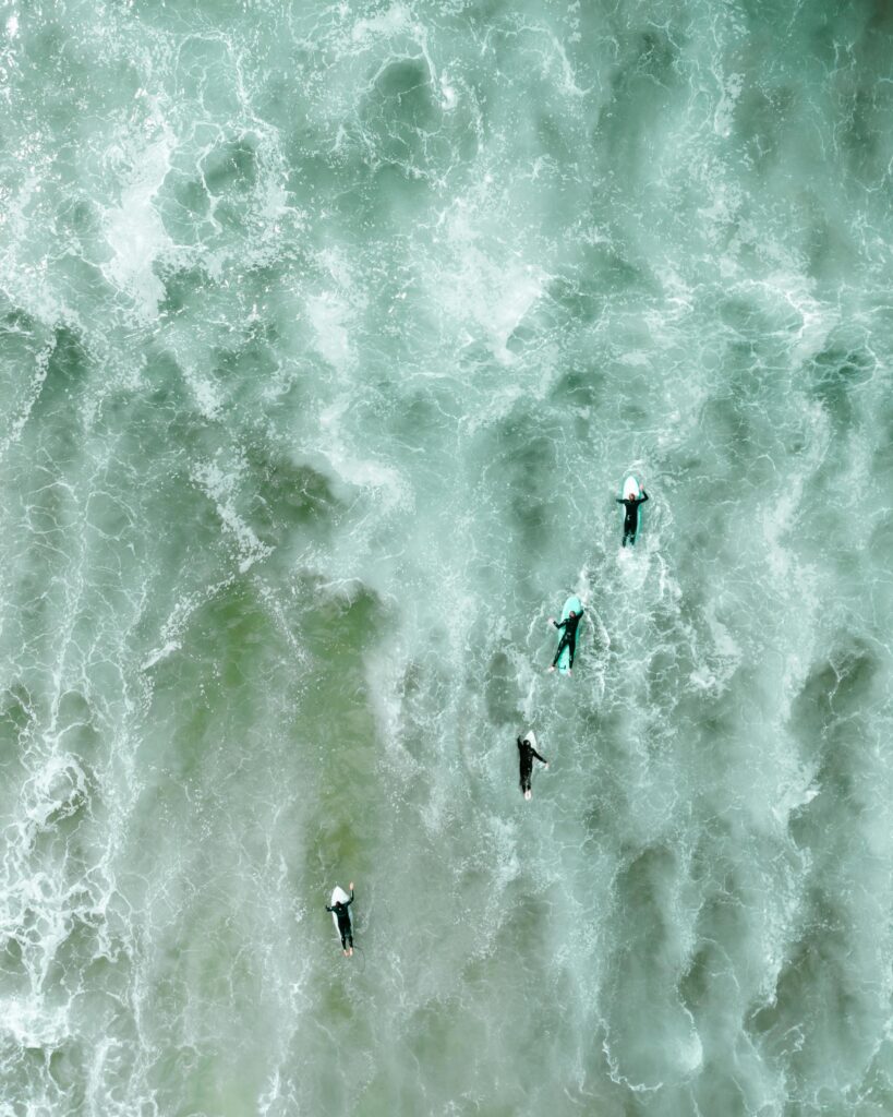grupo de surfistas remando con fuerza